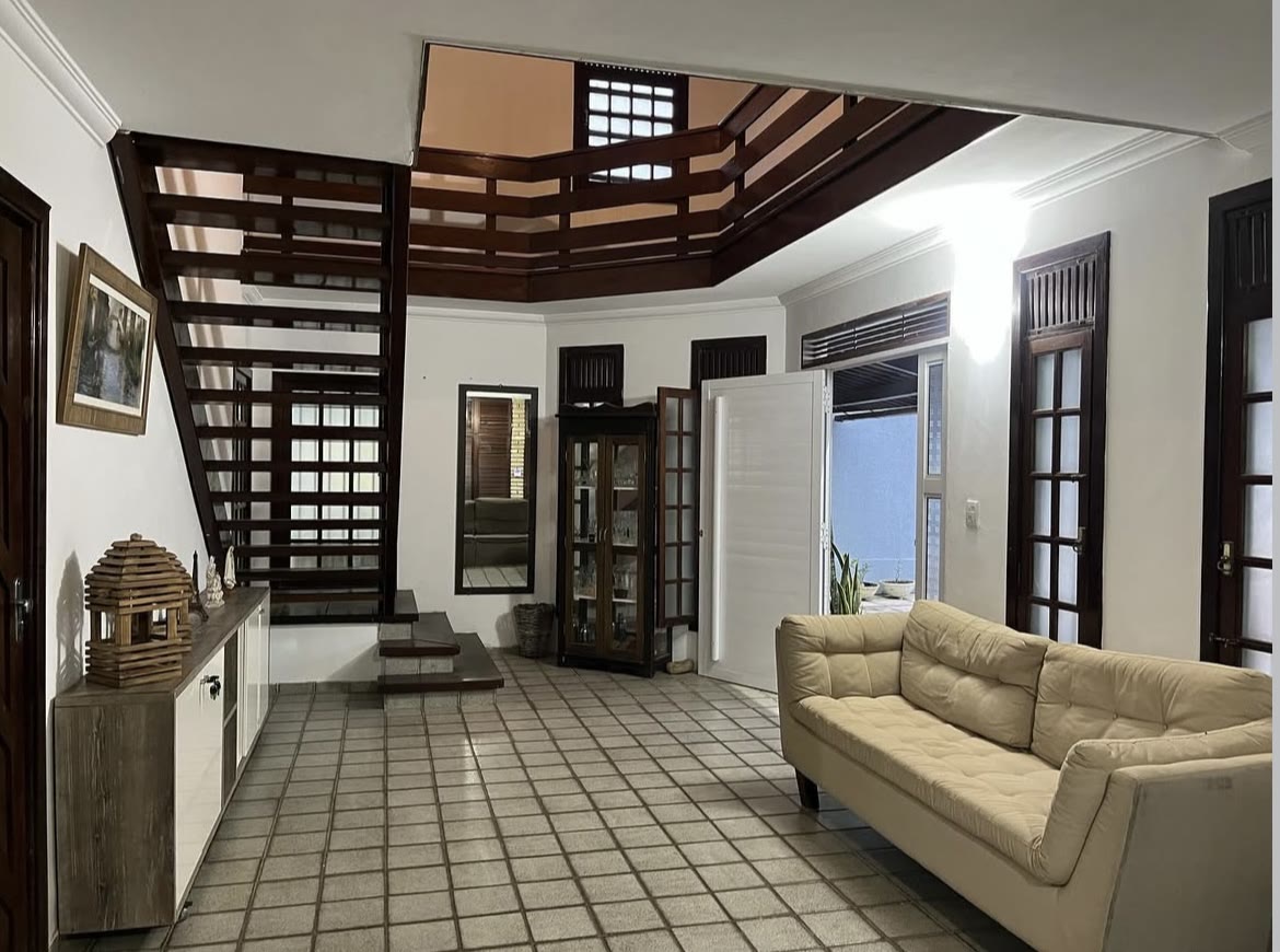 Sala da pousada com sofá e escada